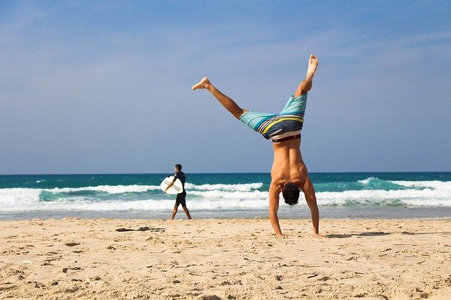 Mann macht Handstand am Strand - Das Maximumprinzip: Einfacher Weg zum Traumkörper?